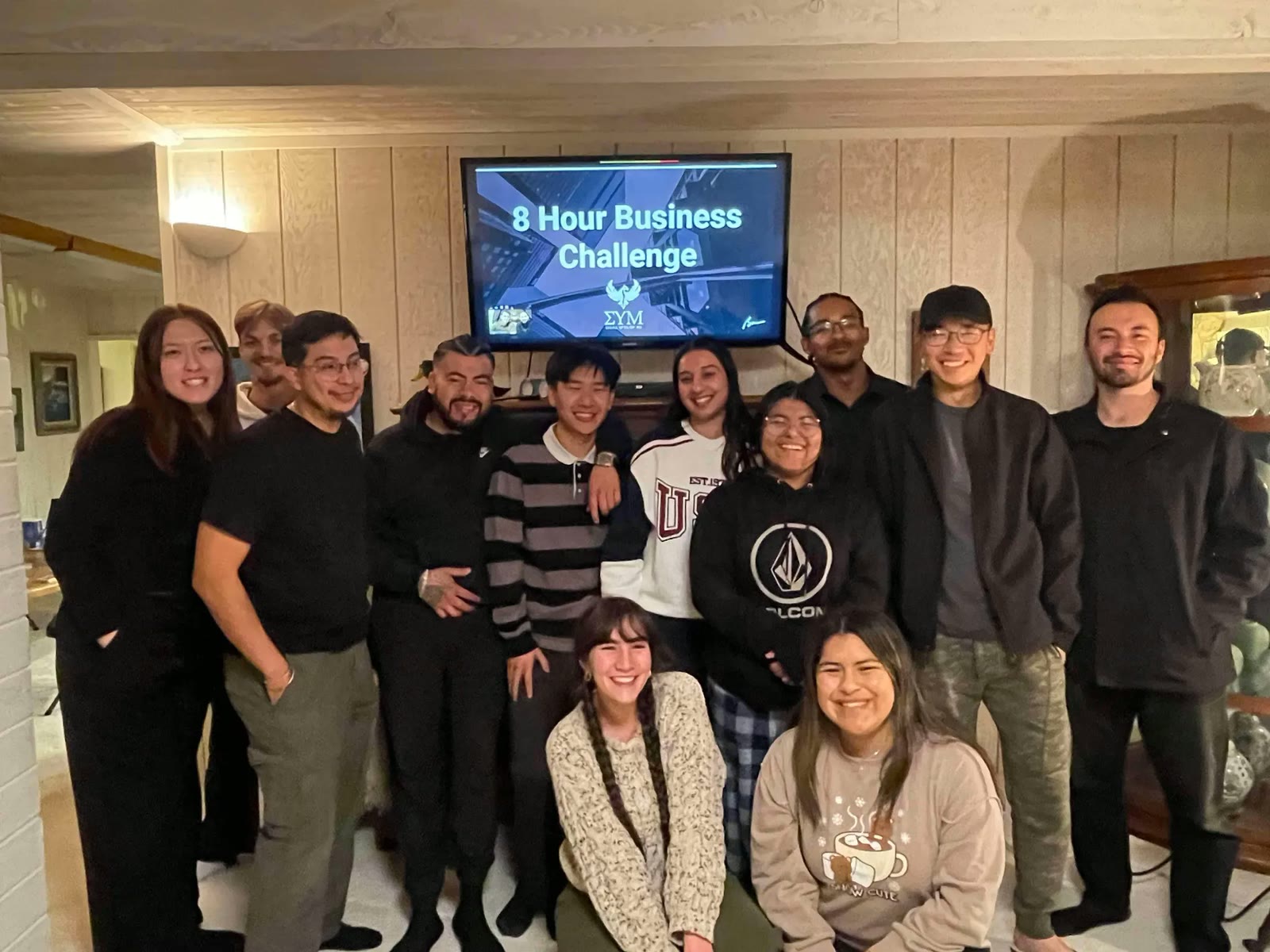 Members gathered around a screen reading 8 Hour Business Challenge at an evening working session